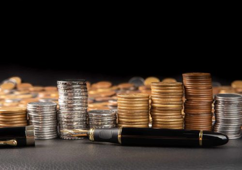 coins-brazilian-coins-various-amounts-piled-up-fountain-pen-black-leather-selective-focus-scaled.jpg
